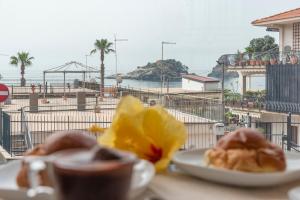 two plates of food on a table with a view of the beach at La Finestra di Verga in Aci Castello