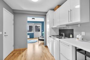 a kitchen with white cabinets and a hallway at Leilighet i Tromsø in Tromsø
