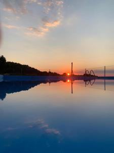 a reflection of the sunset in a body of water at La Cariochaca in Casas Ibáñez