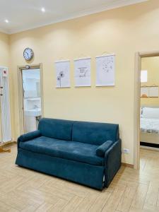 a blue couch in a living room with a clock on the wall at Villino Marcella in Rome