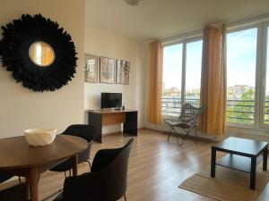 un soggiorno con tavolo, sedie e finestre di NEW Central nr6 Self Checkin OldCity Center Paid Parking with Lift a Timişoara