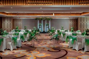 a banquet hall with white tables and green decorations at Courtyard by Marriott Bali Seminyak Resort in Seminyak +85 photos