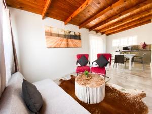 a living room with red chairs and a table at The Mole Guesthouse in Swakopmund
