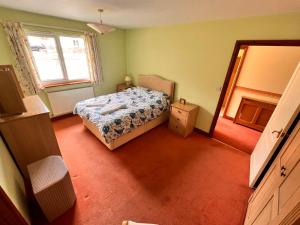 a small bedroom with a bed and a window at Devon Bungalow in Holsworthy