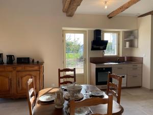 a kitchen with a wooden table with chairs and a dining room at Ecuries Tourangelles in Bréhémont +27 photos