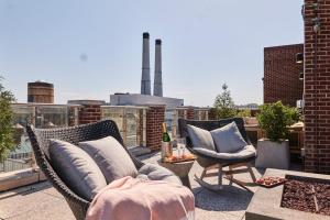 a patio with two chairs and a couch on a roof at The Alida, Savannah, a Tribute Portfolio Hotel in Savannah