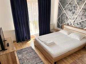 a bedroom with a bed and a large window at Smart Chic Brasov in Braşov
