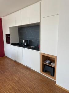a kitchen with white cabinets and a table in a room at Penthouse-Wohnung mit Flussblick in Oldenburg