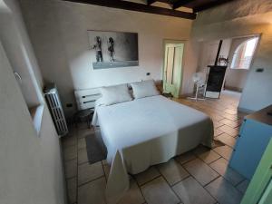a bedroom with a large white bed in a room at Locanda Montecarlo in Lesegno
