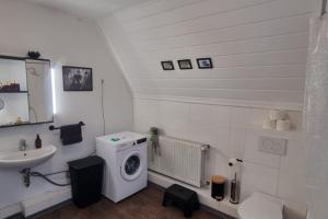 a bathroom with a washing machine and a sink at Celle Apartment for 6 people in Celle