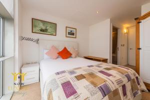 Sidemersey Livings- Unmatched Panoramic Views, Secure Parking, Beautiful Balcony- A Stay to Remember في ليفربول: غرفة نوم مع سرير أبيض كبير مع وسائد ملونة