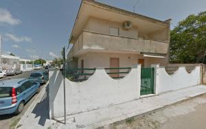 a house with a fence and cars parked on the street at Villetta indipendente a soli 200 metri dal mare in Torre dell'Orso