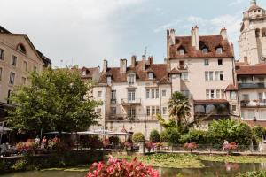 a group of buildings in front of a river at Au Formi'Dole - Terrasse - Vue canal - Centre ville in Dole