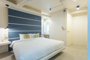 a bedroom with a blue accent wall and a bed at The Light House at Town Phuket in Phuket
