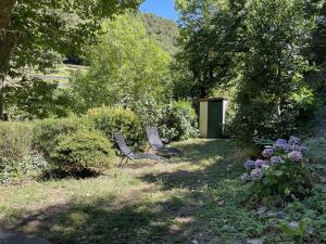 two chairs sitting in the grass in a garden at La Petite école du Valdeyron in Valleraugue