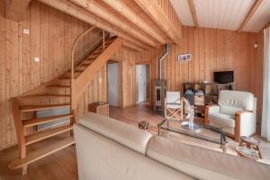 a living room with a couch and a staircase at Maison pour 8 personnes - 300m de la plage in La Roussellerie