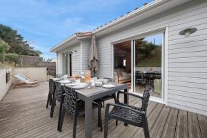 a table and chairs on the deck of a house at Maison pour 8 personnes - 300m de la plage in La Roussellerie +20 photos