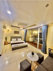 a bedroom with a bed and a couch and a table at Somato Hotel in Phnom Penh