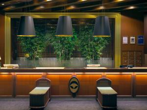 Una barra en un restaurante con dos sillas y luces. en Kumamoto Hotel Castle, en Kumamoto