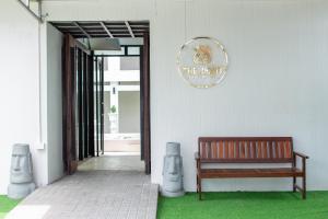a wooden bench sitting in front of a building at The Light House at Town Phuket in Phuket