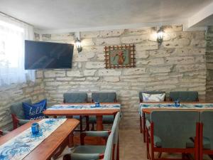 a restaurant with tables and chairs and a stone wall at Casa di Mare - Sauna & Jacuzzi in Balchik