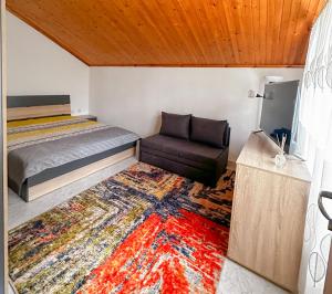 a bedroom with a bed and a couch and a rug at Casa di Mare - Sauna & Jacuzzi in Balchik +26 photos