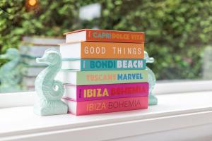 una pila di libri su uno scaffale con un cavalluccio marino giocattolo di Boutique Chalet Putten op de Veluwe a Krachtighuizen