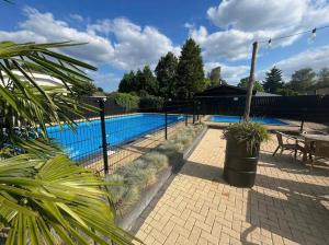 una recinzione attorno a una piscina con un tavolo e una panca di Boutique Chalet Putten op de Veluwe a Krachtighuizen