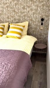 un letto con cuscini gialli e viola in una camera da letto di Boutique Chalet Putten op de Veluwe a Krachtighuizen Altre 44 foto