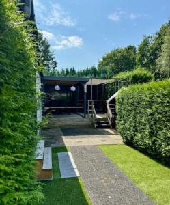 un giardino con un edificio e alcuni cespugli di Boutique Chalet Putten op de Veluwe a Krachtighuizen