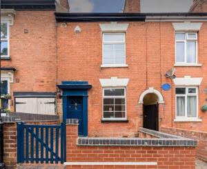 a brick house with a blue door and windows at Luxury House - 2 x Double Beds w Ensuites in Spon End