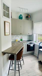 a kitchen with a table and a sink and a stove at Luxury House - 2 x Double Beds w Ensuites in Spon End