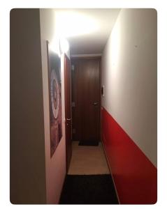Appartamento in Centro Storico - Boutique في كلوسوني: ممر به باب بني وجدار أحمر