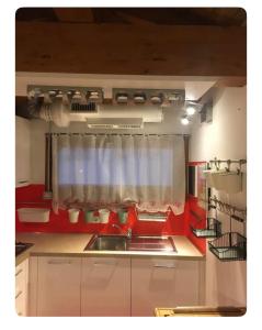 Appartamento in Centro Storico - Boutique في كلوسوني: مطبخ مع حوض ونافذة +صورتان