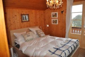 Un dormitorio con una cama grande con una lámpara de araña. en Héloïse, en Arveyes