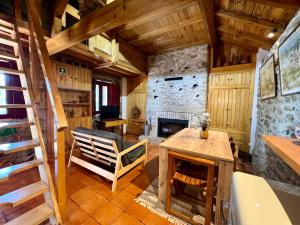 a living room with a stone fireplace and a chair at Aveleira EcoCasa in Melgaço