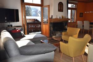 a living room with a couch and chairs and a fireplace at La Gare 4 in Arveyes