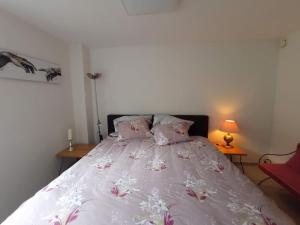 a bedroom with a bed with pink flowers on it at Le jardin d'Horace o Im Garten von Horaz in Volgelsheim