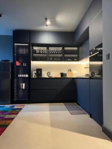 a kitchen with black cabinets and a refrigerator at Apartament Panorama in Pomorie +5 photos