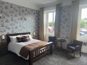 a bedroom with a bed and a wall covered in wallpaper at Long Quay House in Kinsale