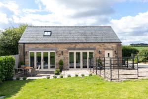 a brick cottage with a patio and lawn at Short Croft Cottage - Idyllic, dog-friendly country retreat in Holbeck