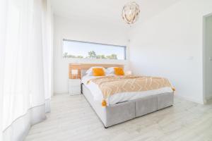 ein weißes Schlafzimmer mit einem Bett und einem Fenster in der Unterkunft Villa Alva in Aroeira + 29 Fotos