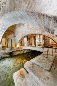 an old stone building with a river in it at La Prévôté - Hôtel Particulier & Restaurant in LʼIsle-sur-la-Sorgue