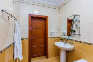 a bathroom with a sink and a toilet and a mirror at Five Villas Hotel in Almaty +31 photos