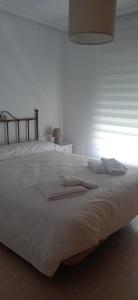 サン・ファン・デ・ロス・テレロスにあるCasa alberoのタオルが敷かれた大きな白いベッドのある寝室