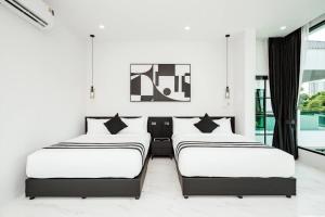 2 Betten in einem Zimmer mit weißen Wänden und Fenstern in der Unterkunft Sea'cret Stay Villa Pattaya พัทยา พูลวิลล่าพัทยา ใกล้ทะเล in Na Jomtien + 42 Fotos