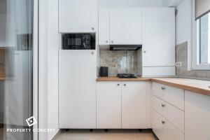 une cuisine avec des armoires blanches et une fenêtre dans l'établissement Central Residence Apartment 711 B4, à Vatra Mînăstirii Cotroceni