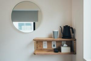 a mirror on a wall next to a shelf at MEANDER Osaka in Osaka