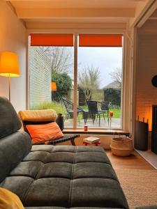 a living room with a couch and a large window at Rekerlanden 6 in Warmenhuizen