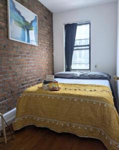 Bett in einem Zimmer mit Ziegelwand in der Unterkunft Chic One Bedroom Retreat in Downtown Manhattan in New York